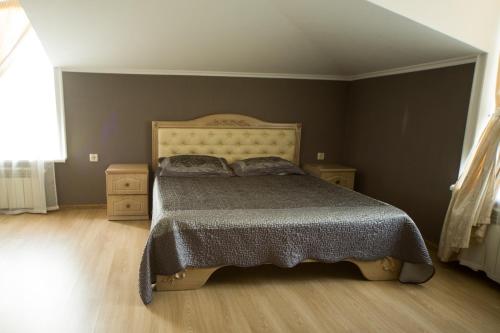 a bedroom with a bed with a wooden floor at Kolyada Hotel in Odesa