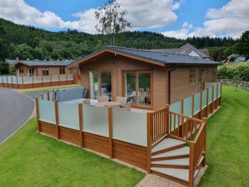 a house with a large deck and a house at Llyn Conwy Lodge in Betws-y-coed