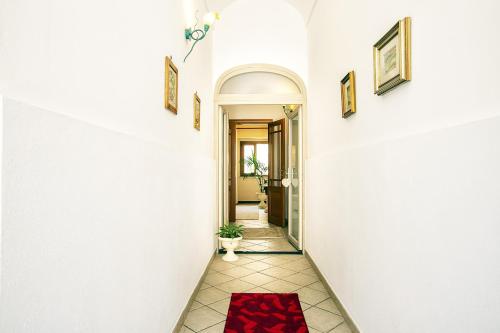 a hallway of a house with a red rug on the floor at La casa di Lo, marina di Sorso in Sorso