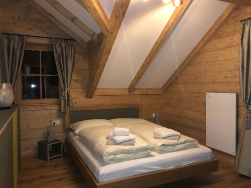 1 dormitorio con 1 cama en una habitación con paredes de madera en Mankerl Hütte Lachtal, en Lachtal