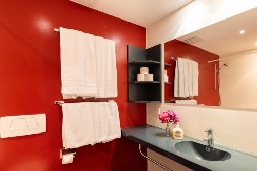 a bathroom with a sink and a red wall at Apart Holidays in Morschach
