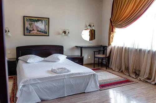 a bedroom with a white bed and a window at Boutique hotel Persona in Novokuznetsk