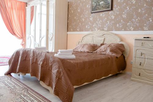 a bedroom with a bed and a dresser and a window at Kolyada Hotel in Odesa