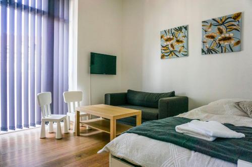 a bedroom with a bed and a couch and a table at Vorhalle Apartment in Hagen