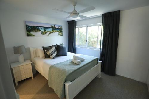 a bedroom with a large bed and a large window at Peregian Court Resort in Peregian Beach