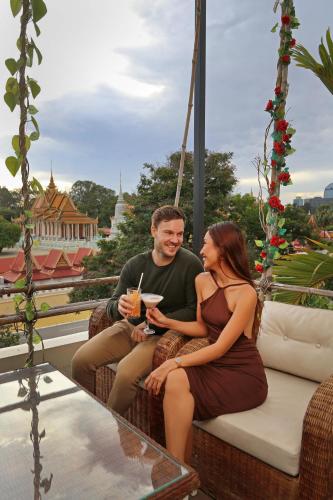 a man and a woman sitting on a swing at Palace Gate Hotel & Resort By EHM in Phnom Penh