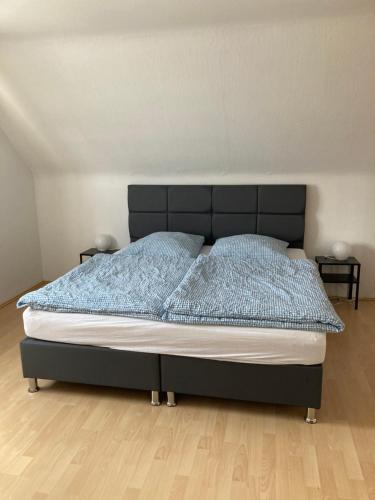 ein Bett mit einem schwarzen Kopfteil in einem Schlafzimmer in der Unterkunft Ferienwohnung auf Alzen in Alzen