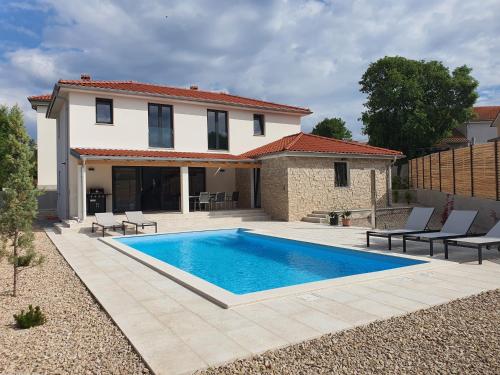 eine Villa mit einem Swimmingpool vor einem Haus in der Unterkunft Villa Zora in Rasopasno