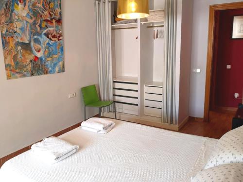 バレンシアにあるCity of Artsのベッドルーム1室(ベッド1台、緑の椅子付)