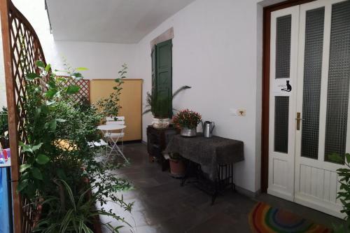 einen Flur mit Tür und Tisch und Pflanzen in der Unterkunft Bike Civico 17 AFFITTA CAMERE in Venzone