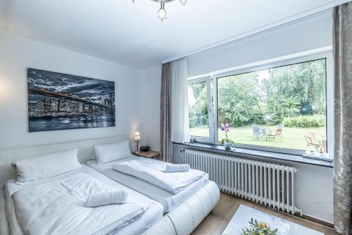 een slaapkamer met 2 bedden en een groot raam bij Backskiste - Studioapartment im Erdgeschoss mit Gartenmitbenutzung in Flensburg