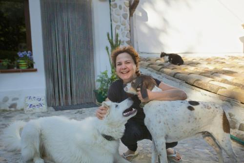 a woman is holding a goat and a dog at B&B Molino Del Gobbo in SantʼAgata Feltria