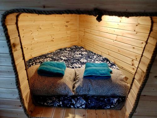 drewnianym łóżkiem z 2 poduszkami w pokoju w obiekcie Roosa maja parvesaunaga w mieście Reigi