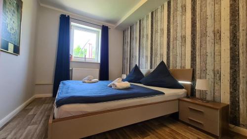 1 dormitorio con cama con sábanas azules y ventana en 08 Heuwiese, en Parchtitz
