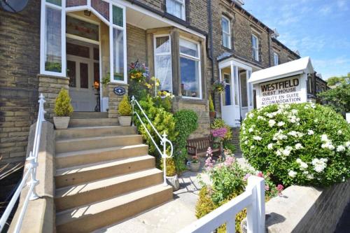 a house with a staircase in front of it at Westfield House - Characterful 7 bedroom townhouse in Skipton