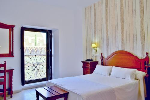a bedroom with a white bed and a window at Hotel Marisa in Córdoba