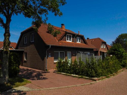 une maison brune avec un toit rouge dans l'établissement Ferienhaus Kristina, à Hooksiel
