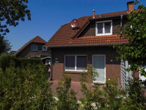 une maison en briques avec un toit brun dans l'établissement Ferienhaus Kristina, à Hooksiel