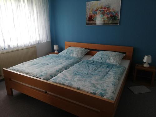 a bedroom with two beds and a blue wall at Annettes Ferienwohnung in Michelstadt