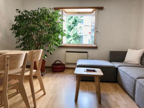 un soggiorno con divano e tavolo di Centrally Located Apartment in Poschiavo a Poschiavo