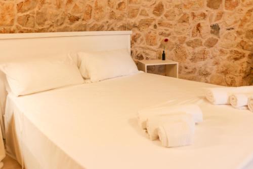 Un dormitorio con una cama blanca con toallas. en Trullo TerraNostra villa con piscina Torre San Giovanni, en Ugento