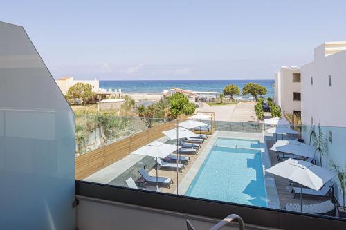 a balcony with a view of a swimming pool and the ocean at Eleven Boutique Suites in Stavromenos