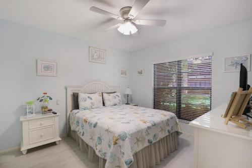 une chambre avec un lit et un ventilateur de plafond dans l'établissement Relaxing condo with two pools and steps to beach, à Marco Island