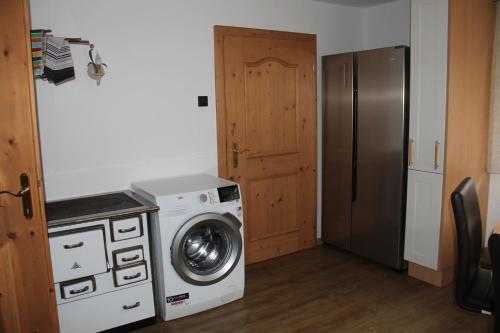 a kitchen with a washing machine and a refrigerator at Hotel Schweizerhof in Oberau