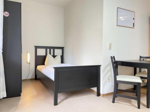Schlafzimmer mit einem Bett, einem Schreibtisch und einem Stuhl in der Unterkunft SAD171 - Monteurappartement in super Lage in Schwandorf in Bayern