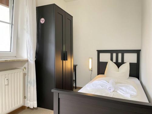 Schlafzimmer mit einem Bett mit weißer Bettwäsche und Kissen in der Unterkunft SAD171 - Monteurappartement in super Lage in Schwandorf in Bayern