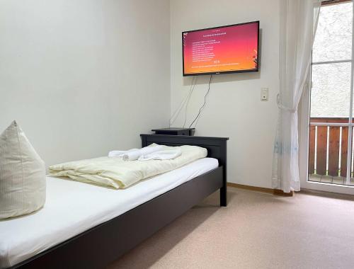Schlafzimmer mit einem Bett und einem Flachbild-TV an der Wand in der Unterkunft SAD171 - Monteurappartement in super Lage in Schwandorf in Bayern