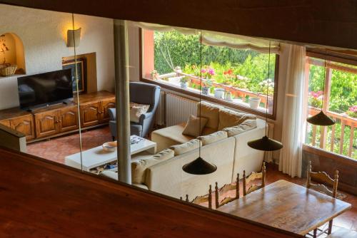 een woonkamer met een bank en een groot raam bij Suite deluxe en casa rural in Bas