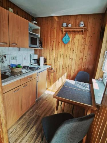 eine Küche mit Holzschränken und einem Tisch mit Stühlen in der Unterkunft Ferienbungalow im Igelbau in Baabe
