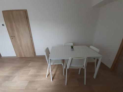 a white table and chairs in a room at Valen apartmány Valtice in Valtice