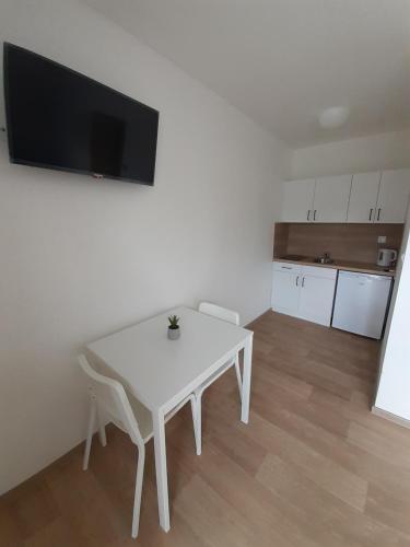 a white table and chairs in a room with a kitchen at Valen apartmány Valtice in Valtice