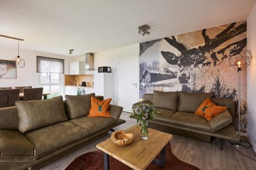 a living room with two couches and a table at UplandParcs Residence Astenberg in Winterberg