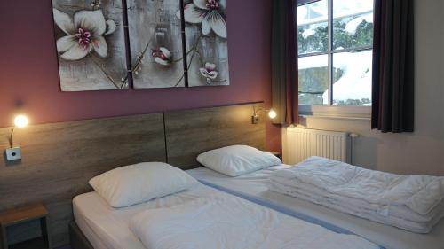 two twin beds in a bedroom with a painting on the wall at UplandParcs Residence Astenberg in Winterberg