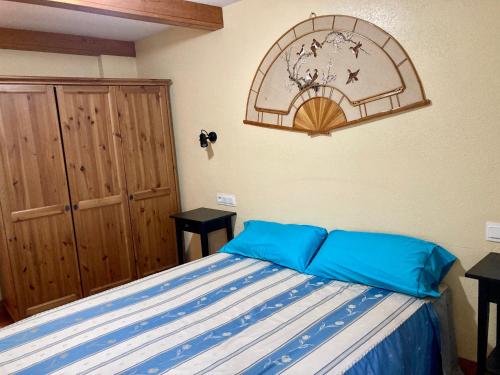 a bedroom with a bed with blue pillows on it at Rincón de Altikarra in Undiano