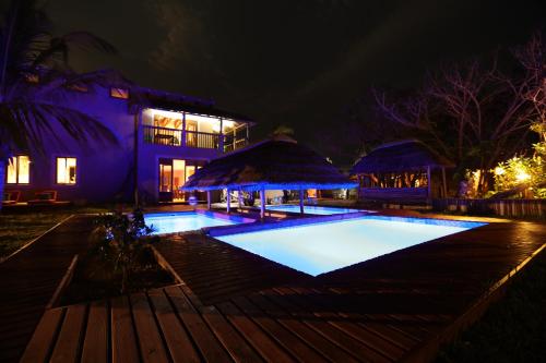 a swimming pool in front of a house at night at Kosi Bay Lodge in Manguzi