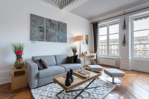 ein Wohnzimmer mit einem Sofa und einem Tisch in der Unterkunft Host inn Lyon - Appartement de Luxe aux Terreaux & Jacuzzi in Lyon
