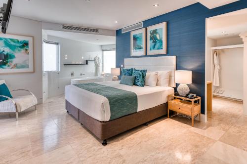 a bedroom with a large bed with blue walls at Oceans Mooloolaba in Mooloolaba