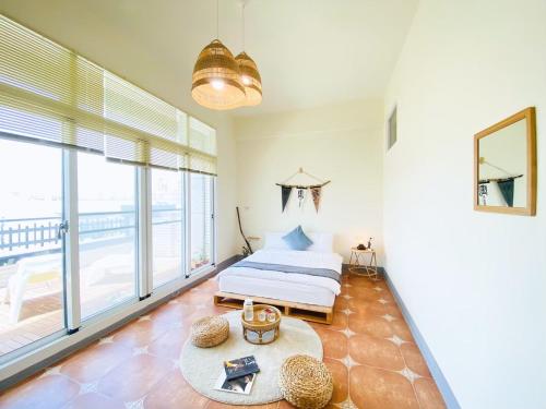 a bedroom with a bed and a large window at 亀居Kameshuku in Hengchun