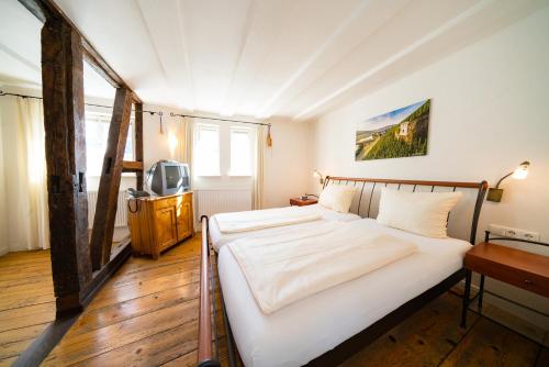 a bedroom with two beds and a television in it at Gästehaus Ratsschänke in Zeltingen-Rachtig