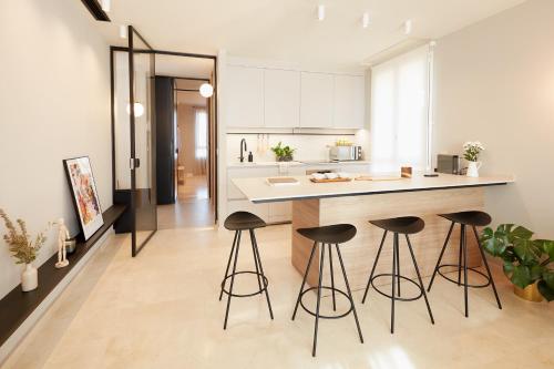 a kitchen with four bar stools and a counter at Vip House Ainsa in Aínsa