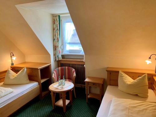 Cette chambre comprend 2 lits et une table. dans l'établissement Gasthof Hartl Zum Unterwirt, à Türkenfeld