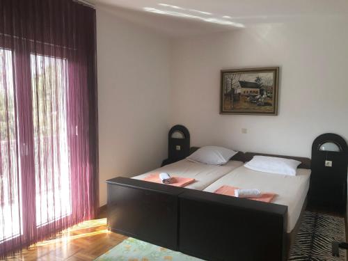 a bedroom with a large bed and two windows at Ferienwohnung Dalmatien in Dugi Rat