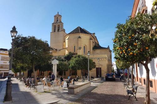 a street with a building with a clock tower at Apartamento San Pedro-Corredera in Córdoba
