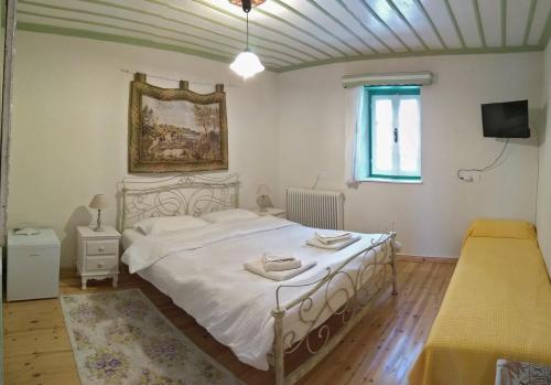 a bedroom with a large white bed and a window at Guesthouse Iro in Papigko