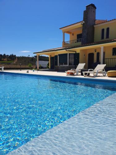a villa with a swimming pool in front of a house at Eagle House in Sao Pedro de Tomar