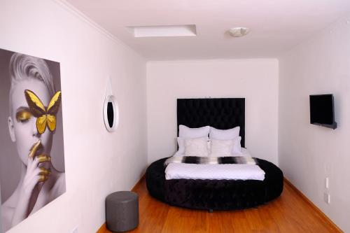 a bedroom with a bed in a room with white walls at Selina Airport Lodge #Emzini in Kempton Park